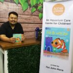 Coach John Meria holding the Fish Be with You aquarium care guide